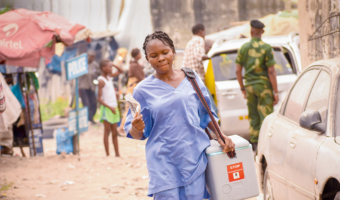 a health worker transports the day's vaccines from the health zone's central bureau to the health facility in Kinshasa.