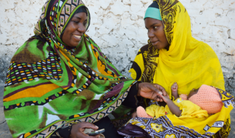 A community health volunteer in Zanzibar, guided by a mobile phone tool, counsels a new mother
